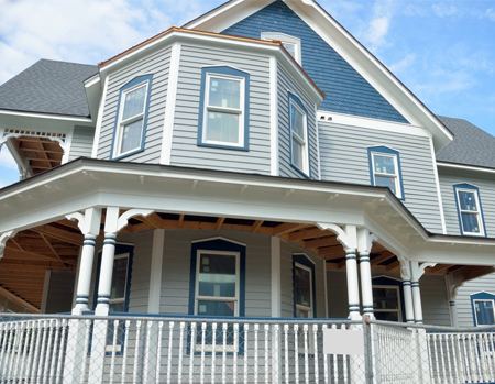 front of a blue house with a wrap-around porch