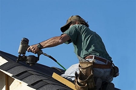 roofing contractor installing new roof shingles in Saginaw, MI